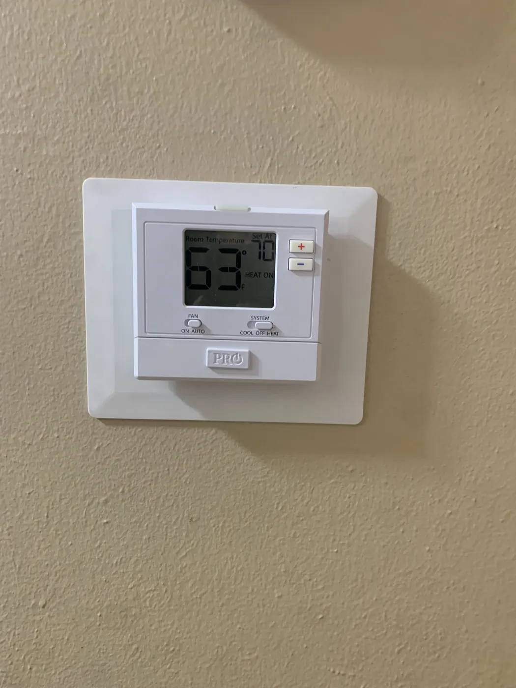 A replacement thermostat installed on a home wall